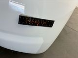 the back end of a white car with a sticker on it ' s bumper