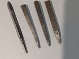 quatre types d'outils différents posés sur une surface blanche