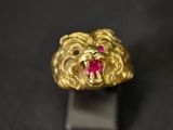 Gros plan sur une bague en or ornée d'une pierre rouge