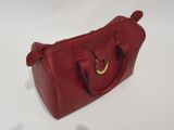 a close up of a red handbag on a white surface