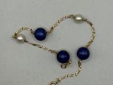 un gros plan d'un collier de perles bleues posé sur une surface blanche