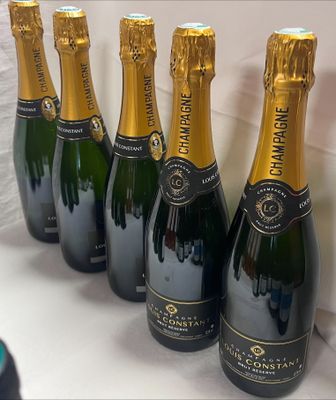 six bouteilles de champagne alignées en rang sur une table