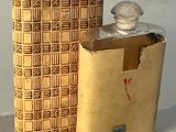 une flasque en or et une boîte posées sur une table