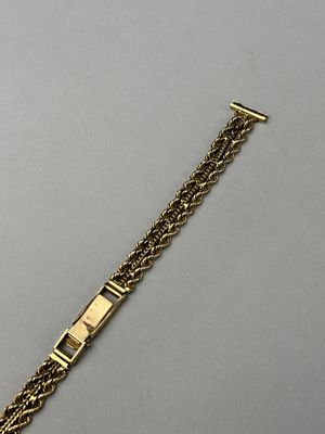 a close up of a gold bracelet on a gray surface