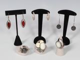Trois paires de boucles d'oreilles sont présentées sur un présentoir noir
