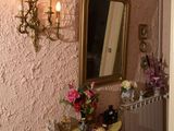 une petite table sur laquelle se trouvent un miroir et un vase