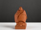 an image of a clay statue of a monk on a white table