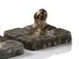 a statue of a dog sitting on top of a stone block