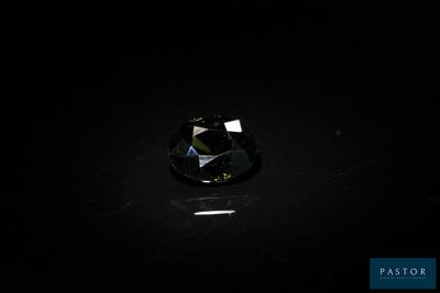 un gros plan d'un diamant noir sur une surface noire