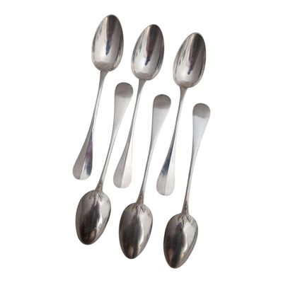 six silver spoons are lined up in a row on a white surface