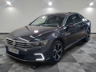 une Volkswagen Passat grise garée sur un sol en carrelage à damier