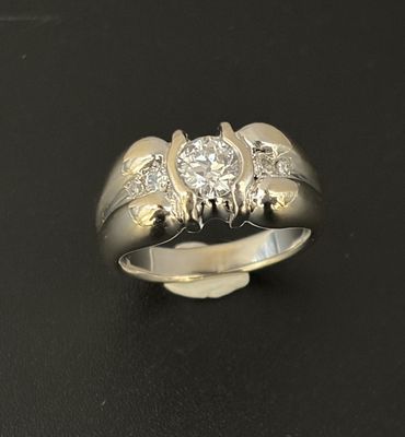 une image d'une bague en diamant sur une surface noire