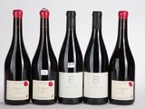 six bouteilles de vin rouge sont alignées sur une surface blanche