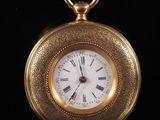an image of a gold pocket watch with roman numerals on the face
