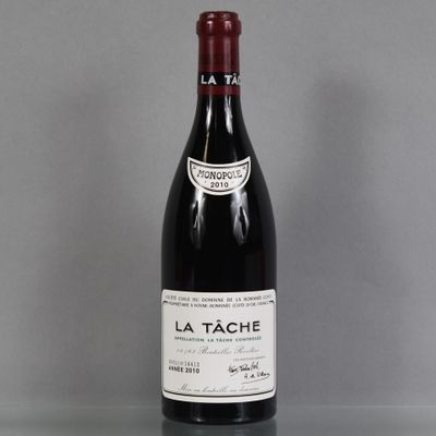 bottle of red wine on a glass table with a gray background