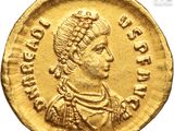 a close up of a gold coin with a woman on it