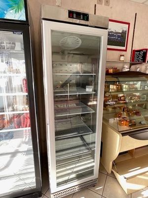 two refrigerators that are sitting in a room