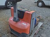 a forklift sitting on a pallet in a parking lot