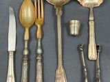 a lot of silver spoons and spoons on the table