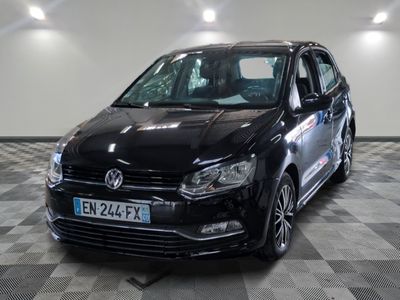 the black volkswagen polo is parked on a checkered tile floor