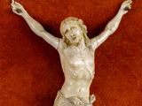 a statue of jesus on the cross on a red surface