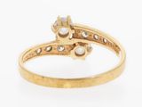 a close up of a gold ring with diamonds and pearls