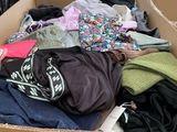 a cardboard box filled with clothes and other items