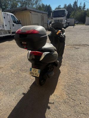 une moto garée sur un parking, avec un camion en arrière-plan