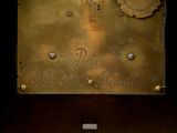 a gold clock that is on display in the dark