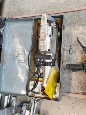 a box with a drill and other tools on the ground