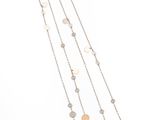 un gros plan d'un long collier sur fond blanc