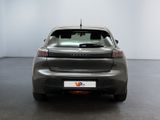 the back of a grey car in a room with a white wall