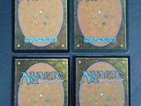 four magic the gathering cards are sitting on a table