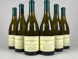 six bouteilles de vin sont alignées sur une table