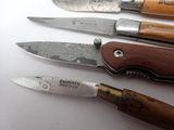 several different types of knives are lined up on a white surface