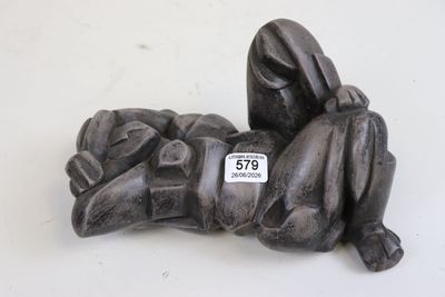 une statue représentant une personne allongée sur une surface blanche