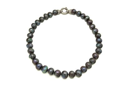 un gros plan d'un bracelet de perles noires sur fond blanc