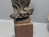a statue of a woman sitting on top of a wooden block