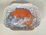 une assiette décorée d'un motif de poisson, posée sur une table