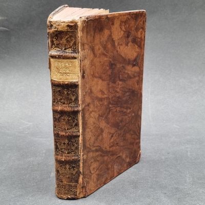 an old book sitting on top of a table next to a gray background