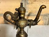 an old brass teapot with a handle and a bird on it