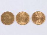 Trois types différents de pièces d'or sont représentés sur un fond blanc