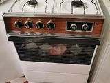 une cuisinière installée dans une cuisine au sol carrelé en damier
