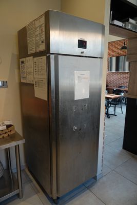 a refrigerator in the corner of a kitchen with a table and chairs