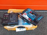 une petite boîte posée par terre, sur laquelle se trouvent des outils