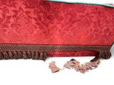 a red bag with tassels on it on a white surface
