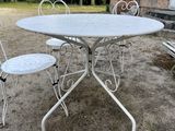 a white table and chairs outside in the yard