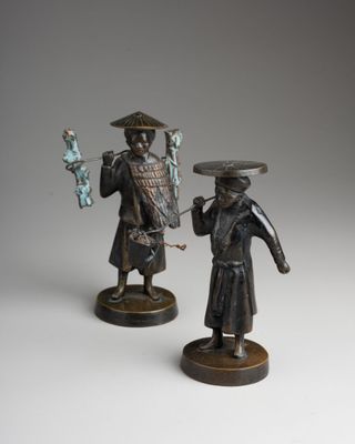 pair of bronze figurines of a man and a woman holding fish
