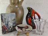 a picture of a vase, a plate, and a picture on a table