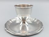 une tasse et une soucoupe en argent posées sur un plateau en argent
